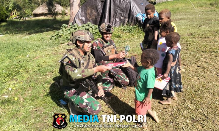 Prajurit Buaya Putih Kostrad Bagi-Bagi Buku Tulis Untuk Anak-Anak Kampung Kago