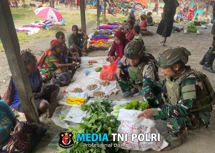 Personil Pos Sinak Satgas Yonif 700/WYC Belanja Hasil Tani Masyarakat di Pasar Sinak mama Papua tersenyum Bahagia