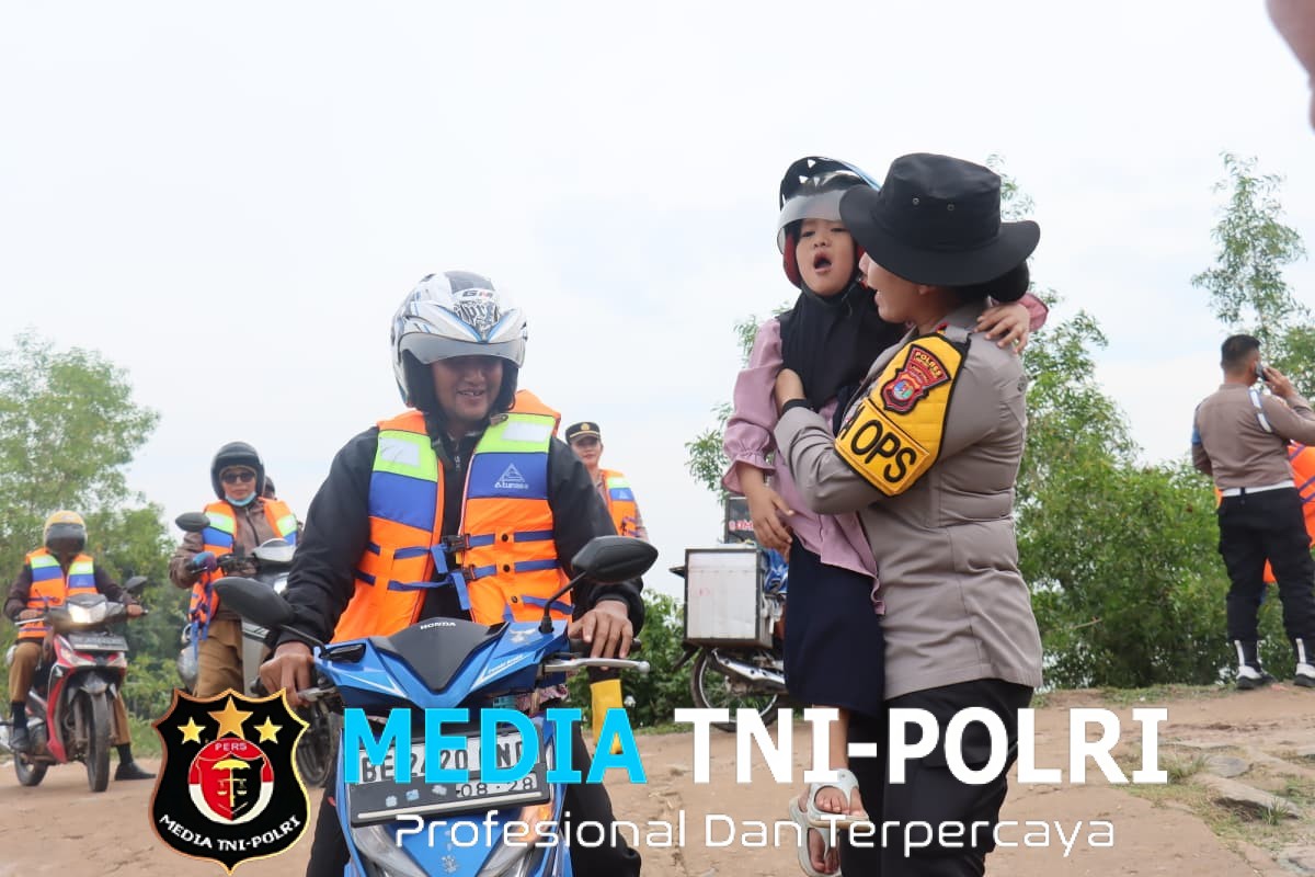 Polres Lampung Timur Siagakan Personel Bantu Penyebrangan Warga dan Anak Sekolah di Sungai Way Bungur