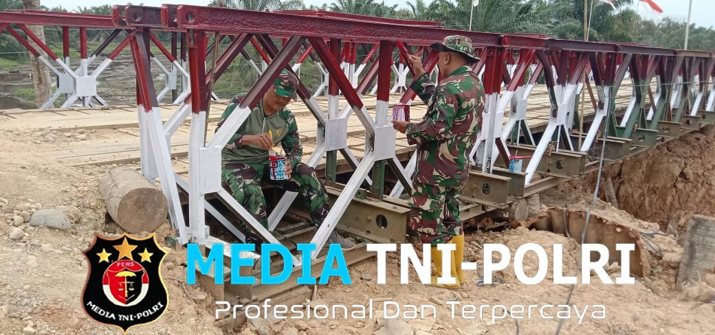 Anggota Koramil 13/Baktiya Fokus Lanjutkan Pengecatan Jembatan Belly Penghubung Dua Desa