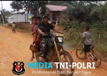 Kepedulian Anggota Satgas TMMD, Mengantar Siswa ke Sekolah Karena Kondisi Jalan Yang Memprihatinkan