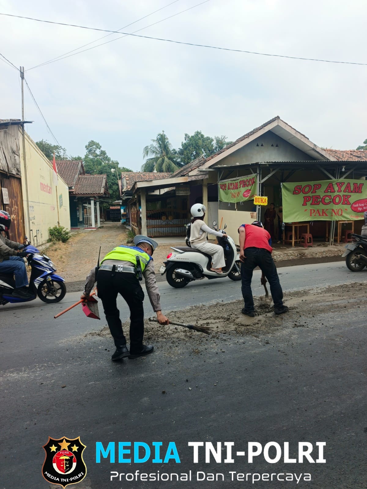 Kanit Lantas Polsek Serang Baru Bersihkan Ceceran Semen di Jalan, Cegah Kemacetan dan Kecelakaan