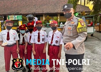 Polres Metro Bekasi, Bhabinkamtibmas Kedungwaringin Atur Lalu Lintas dan Imbau Pelajar Gunakan Masker