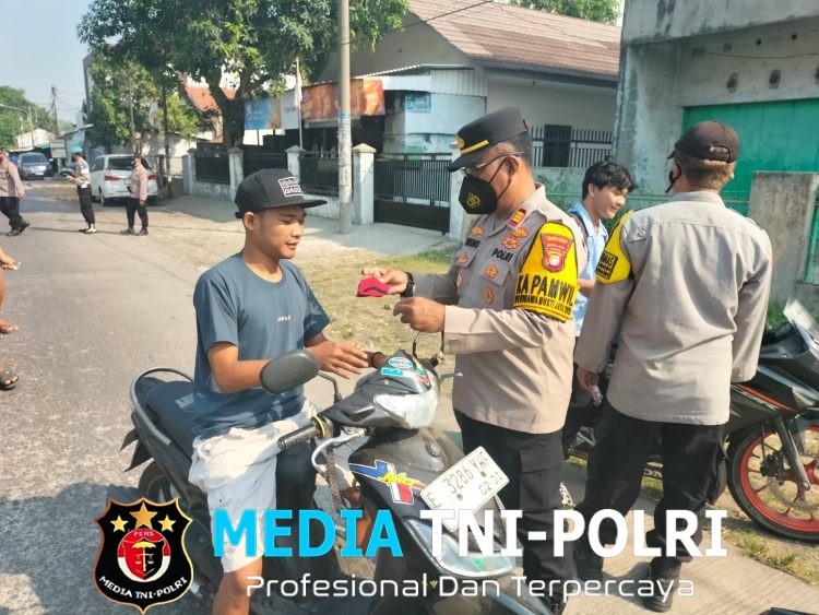 Polres Metro Bekasi, Polsek Kedungwaringin Bagikan Masker kepada Pengguna Jalan Antisipasi Debu Vulkanik