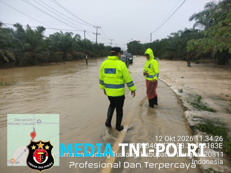 Respons Cepat Laporan Call Center 110, Polsek Padang Tualang Atur Lalu Lintas di Jalan Sumur Bor yang Tergenang Air