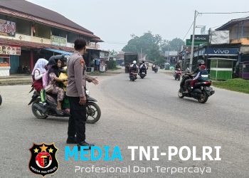 Wujud Nyata Polisi Bersama Masyarakat, Polsek Ngabang Sigap Atur Lalu Lintas dan Bantu Pelajar Menyeberang