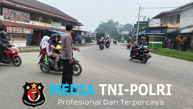 Wujud Nyata Polisi Bersama Masyarakat, Polsek Ngabang Sigap Atur Lalu Lintas dan Bantu Pelajar Menyeberang